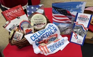 A thoughtfully arranged gift basket featuring handcrafted products made by students. The basket includes a freshly baked fruitcake, homemade fruit jelly, and a selection of patriotic-themed merchandise, showcasing the students' craftsmanship, creativity, and pride in their work.
